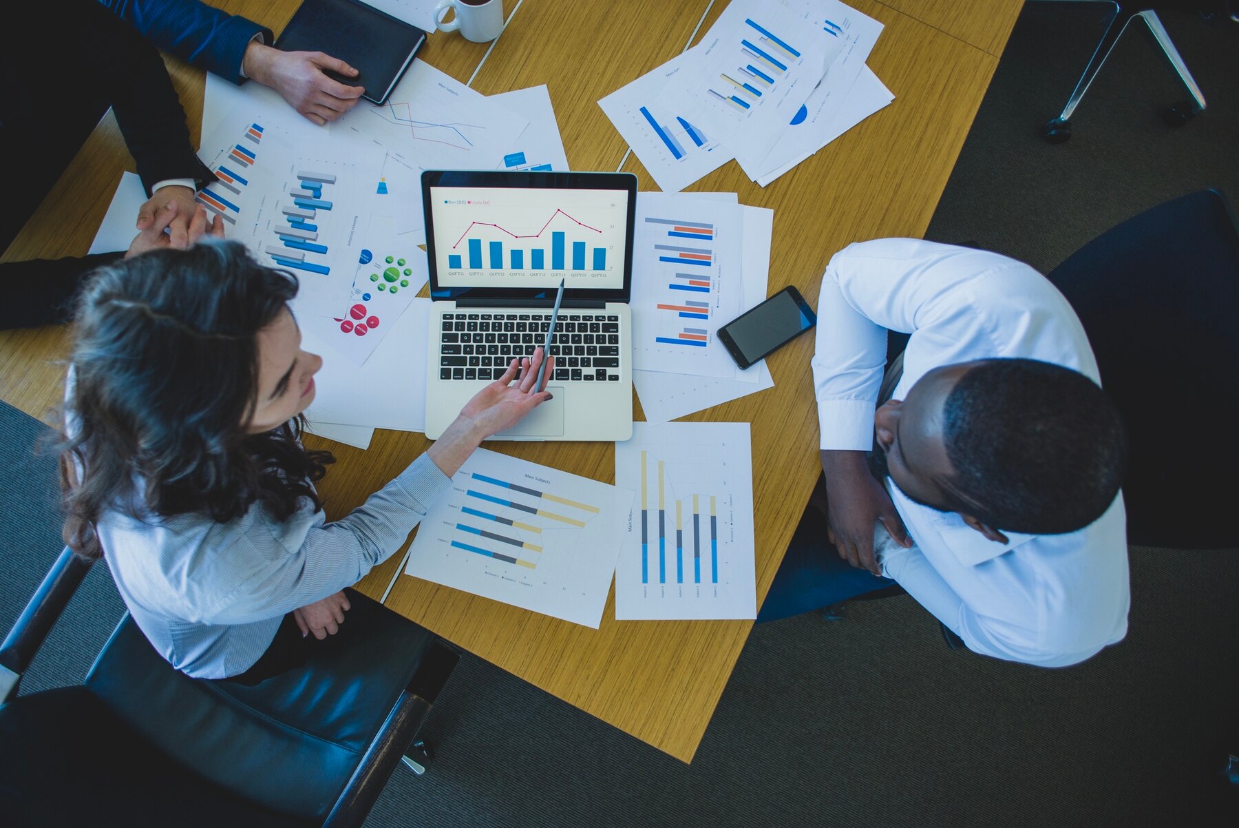 Team discussing business charts and reports around a table
